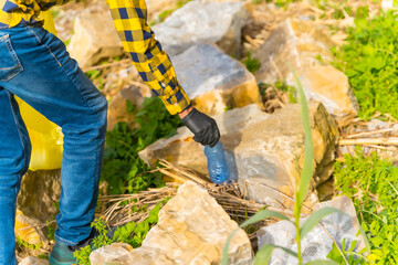 Unrecognizable person collecting plastics in a forest. Ecology concept, recycling