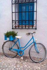 Fototapeta na wymiar Blue bicycle used to decorate with plants the exterior facade of a house in the town of Altea on the Costa Blanca, Alicante.