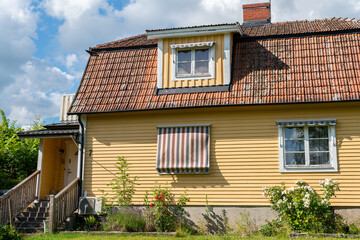 Sweden, Knislinge – July 2, 2022: A beautiful wooden yellow private house in Europe in summer. European architecture, vintage. 