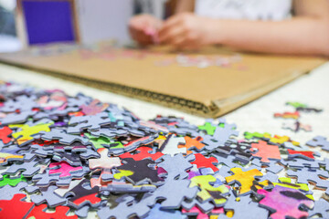 Little girl playing with puzzles at home