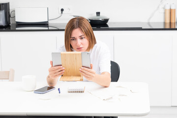 Close up of shocked woman sitting at the table, stressed and confused by calculate expense from invoice or bills, have no money to pay mortgage or loan. High prices and spending money concept