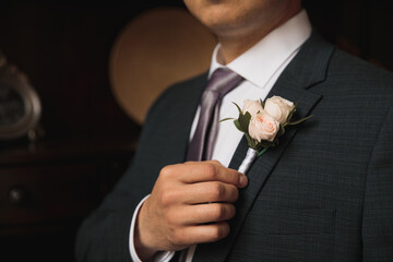 man groom adjusting boutonniere close-up