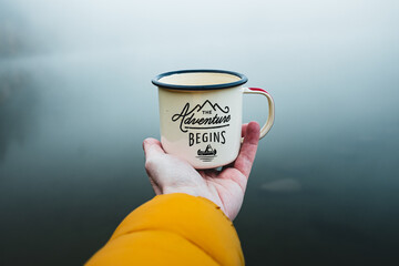 Close-up of human hand holding mug. The adventure begins travel,hiking and camping concept....