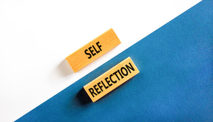 Self reflection symbol. Concept word Self reflection typed on wooden blocks. Beautiful white and blue paper background. Business psychological and self reflection concept. Copy space.