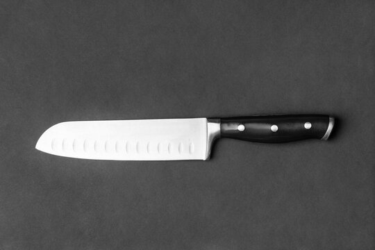 Large kitchen knife on a black background top view