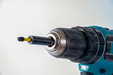 close up of a cross head screw driver bit in a magnetic bit holder of an impact driver battery operated cordless drill