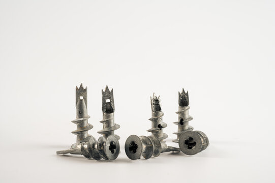 close up of metal galvanised wall plug anchors with screw thread and cross head screw isolated on a white background