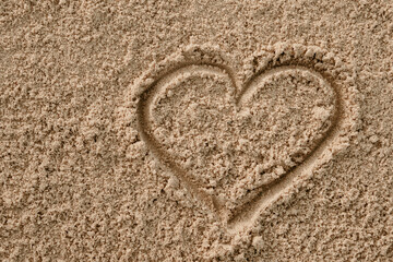 Valentine's heart drawn with a stick on the sand 