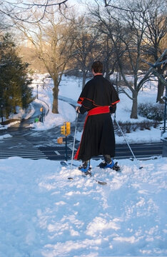 snow in central park with clergy preparing to ski downhill in cassock or soutane 