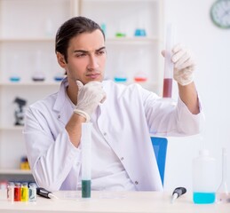 Young male chemist working in the lab