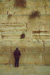 Fototapeta premium Jewish man syanding and praying at the sacred Wailing Wall, Western Wall, Jerusalem
