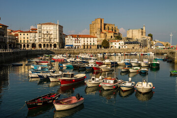 Fototapeta na wymiar Boats in port of Castro Urdiales and the church ‪Iglesia de Santa Maria‬