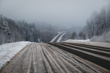 Winter road turn in snowy and frosty forest