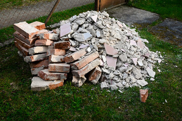 A pile of bricks, stones and rubble from construction intended for disposal, a black dump