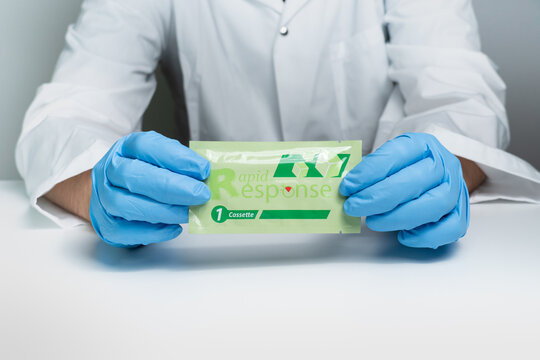 Toronto, Ontario, Canada - December 30, 2022: Male Nurse Holding Covid 19 Rapid Test Kit Given To Shoppers At Grocery Stores And Pharmacies Across The Province. Rapid Antigen Test Package Kit.