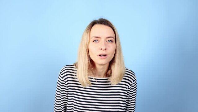 Camera view of amazed shocked young blond woman looking into camera demonstrates wow surprised face expression Happy girl rejoices by sudden incredible news promotion sale on isolated blue background