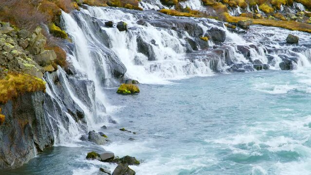 Autumn Waterfall in Iceland. Pure Turquoise Water in Mountain River. Popular Tourist Spot. Famous Travel Destination. Beautiful Nature, Unusual Landscape. Footage Shot in 8K Resolution 4320p