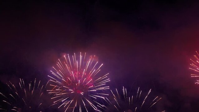 Colorful fireworks festival. Beautiful fireworks close-up view in slow motion. Wonderful real fireworks in the night sky shot with a telephoto lens. fireworks show. 4K slow motion video.