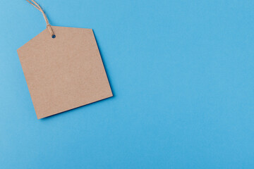Empty brown paper tag tied with string. price tag on blue background
