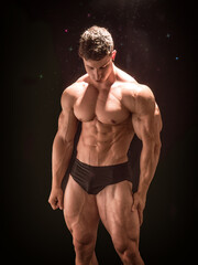 Three quarters shot of handsome shirtless athletic young man