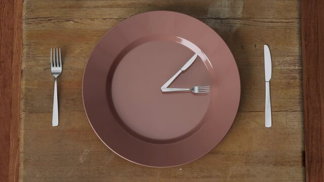 Camera zooming in slowly to an empty dinner plate sitting on a wooden table with a knife and fork rotating on the plate like the hands of a clock.