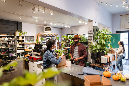 Friendly Housewares Shop Owner Helping Customer At Counter