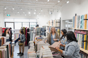 Women shopping, browsing fabric in fabric store