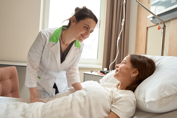 Obraz premium Kind woman doctor bent over the girl