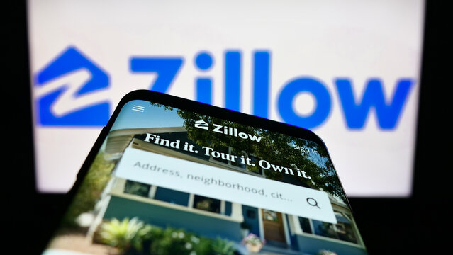 Stuttgart, Germany - 01-01-2023: Mobile phone with website of US real estate marketplace Zillow on screen in front of business logo. Focus on top-left of phone display.