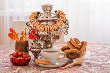 Russian traditions. Tea drinking with a samovar. Still life with a cup of tea, bagels, dried fruits, apple jam, caramel cockerel and Russian samovars. © Юлия Клюева