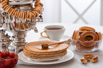 Russian traditions. Russian holiday Maslenitsa. Still life with a cup of tea, a stack of pancakes,...