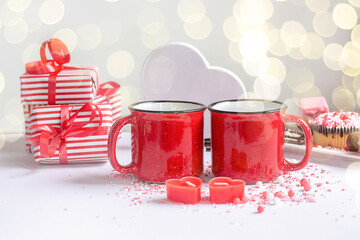 Happy Valentine's Day. Two red cups and a gift for a romantic dinner. Ggift box with small hearts