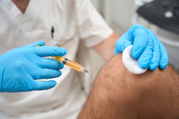 Certified healthcare professional taking a biopsy sample from knee - obrazy, fototapety, plakaty