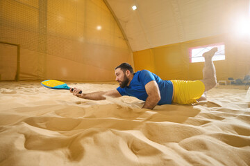 Man touches sand with belly on court for playing frescoball