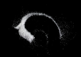 Spilled white sea salt on a black background. clear crystalline pebbles on a black background. Salt...