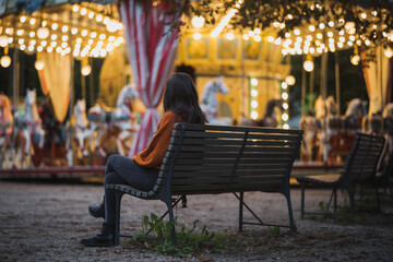 woman watching merry go round carousel at night © Martin Moutayrek ©