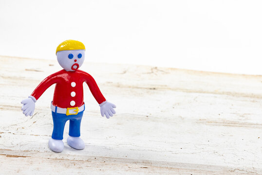 Iconic Mr. Bill posable toy figure isolated on a wooden white table  with a shallow depth of field and copy space
