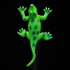 Green lizard toy close up on a black background