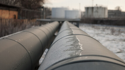 pipeline close-up, oil storage tanks and gray sky in the background