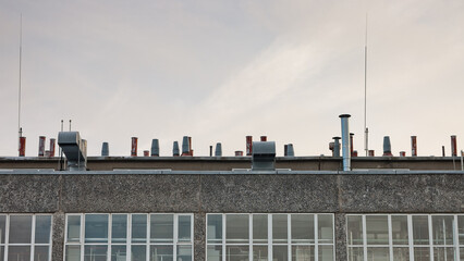 Obraz premium the roof of a building with a large number of ventilation pipes on a gray sky background