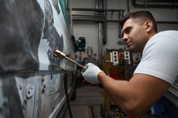Mechanic cleaning surface before applying new paint