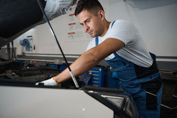 Portrait of young male doing car repairs