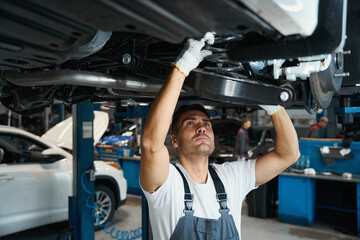Portrait of technician replacing car parts in tire shop