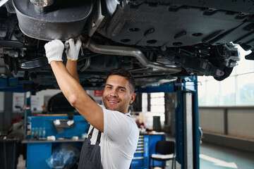 Portrait of smiling engineer replacing car parts in tire shop