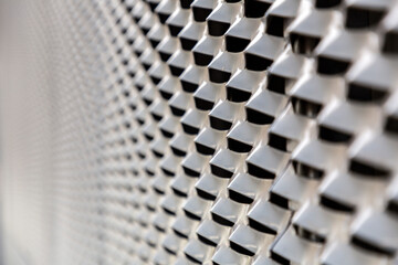 Dark gray perforated metal surface texture background