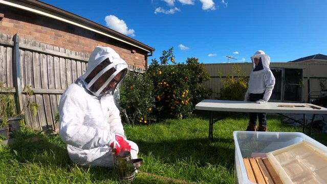 Father and daughter beekeepers with the white protective suit while collecting honey
Healthy organic farm honey.