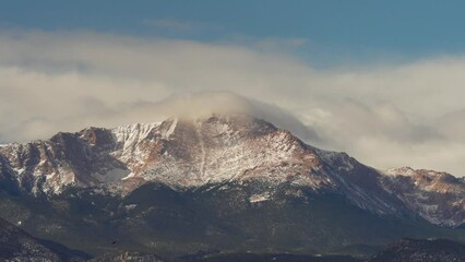 Clouds over a snow covered mountain peak
