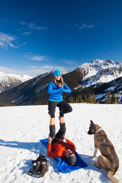 A dog watches his owners preform Acro Yoga.