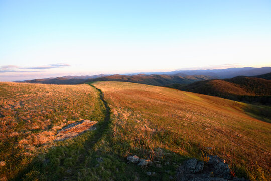 View down the final stretch of the Appalachian Trail to the summit of Max Patch Bald west of Asheville, NC at sunset.