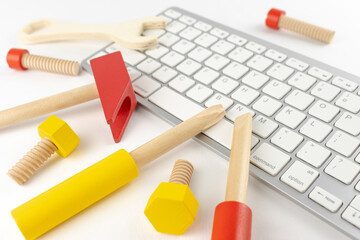 おもちゃの工具と、キーボード。パソコンの修理イメージ
